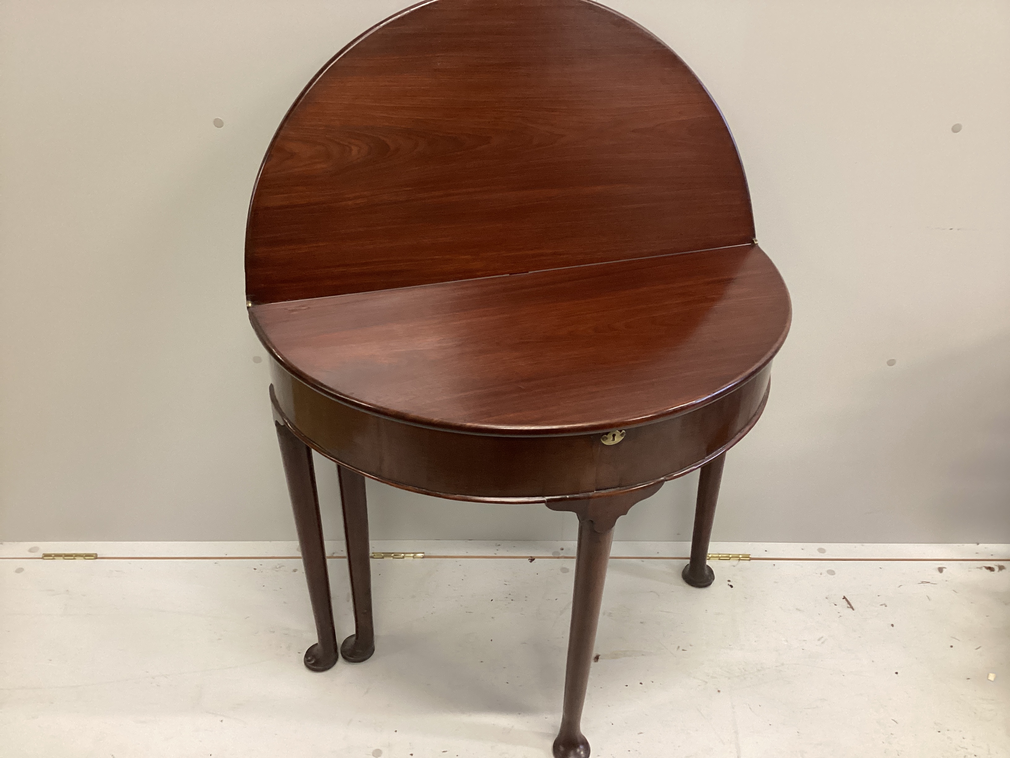 A George III walnut D shaped folding tea table, width 82cm, depth 41cm, height 73cm